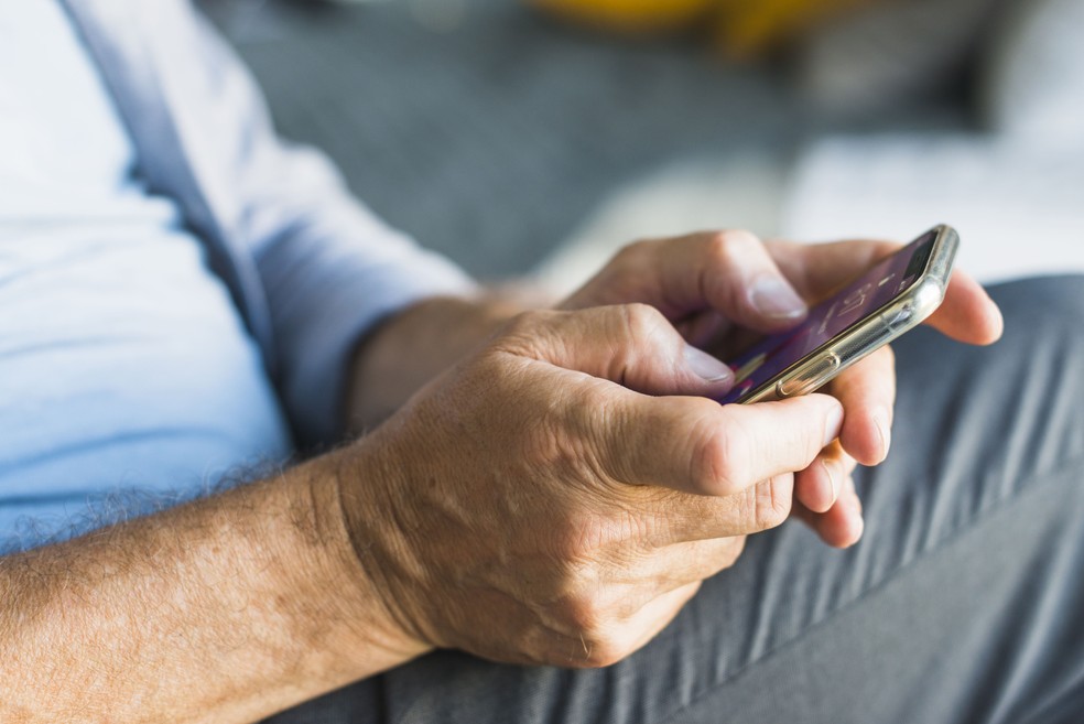 Imagem ilustrativa de um homem mexendo no celular — Foto: Freepik