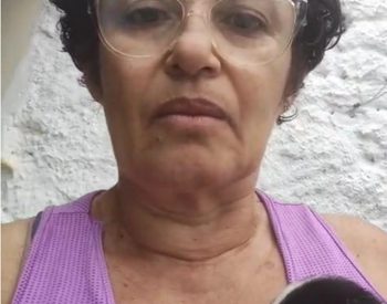 A mulher que salvou o cachorrinho de ser morto por Pedro de Hilda, registra  vídeo segurando o cachorrinho na mãos. Foto — ©Reprodução.