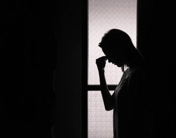 Depressed young woman in a dark room