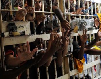 Presidiários em cadeia lotada.