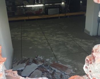 Para entrar na farmácia, os bandidos foram a um terreno baldio que fica por trás do prédio e fizeram um buraco na parede dos fundos do estabelecimento — Foto: Kleber Teixeira/Inter TV Cabugi